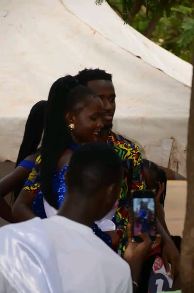 In a blue sequinned dress with kitenge-patterned sleeves, being photographed with other contestants at Miss Manyatta 2022/23 in Kisumu.
